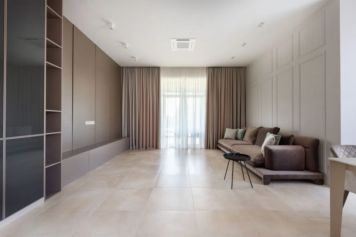 Perdeler, raflar ve koltuk bulunan aydınlık salon